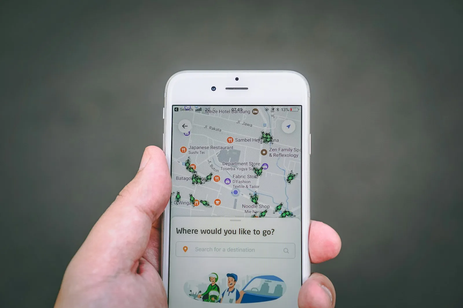 Mão segurando um celular com um aplicativo de mapa aberto