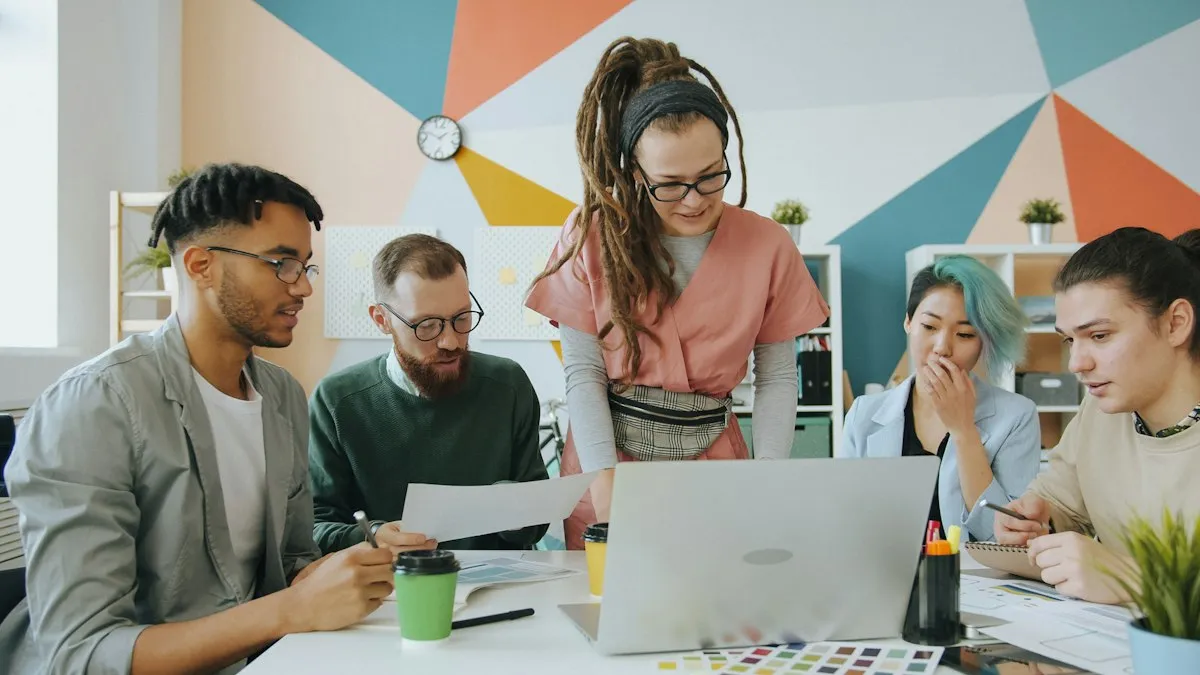 Equipe reunida em volta de uma mesa, olhando juntos para um notebook e para amostras de cores.