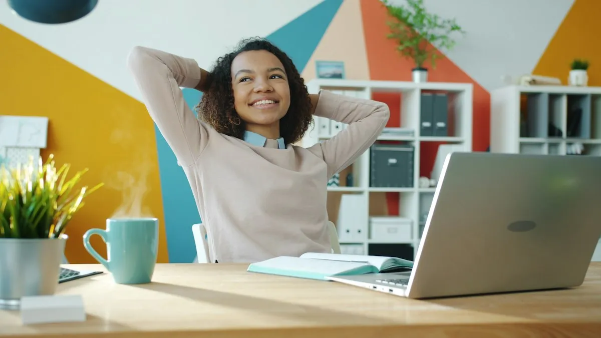Profissional sorrindo, recostada na cadeira diante de um notebook em um escritório colorido